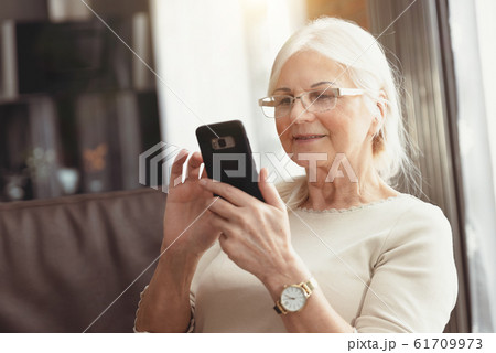 Beautiful senior woman texting at home Beautiful senior woman texting at home 61709973
