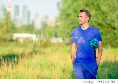 Sportive young man doing sport exercises outdoors in the park 61710194