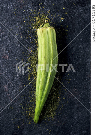 raw okra pod on a black stone surface 61711595