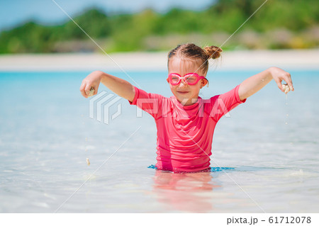 Little adorable girl playing on beach with ball 61712078