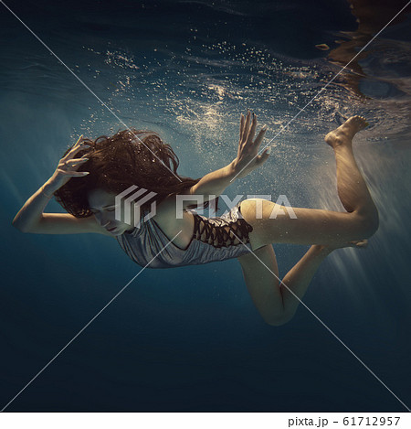 The girl actively swims underwater The girl actively swims underwater 61712957