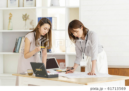 図面を見ながら打ち合わせをする女性二人　ビジネスシーン 61713569