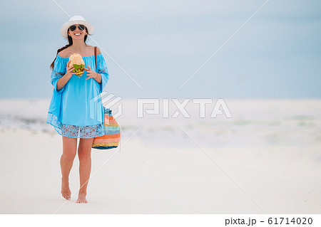 Young woman drinking coconut milk during tropical vacation Young woman drinking coconut milk during tropical vacation 61714020