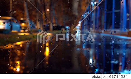 Window glass in rainy day. Bokeh night traffic lights. 61714584