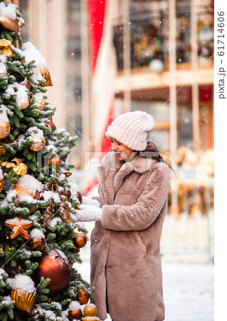 Happy girl near fir-tree branch in snow for new year. 61714606