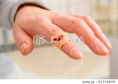 Applying adhesive bandage on finger Applying adhesive bandage on finger 61716649