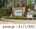 AGIA NAPA, CYPRUS - MAY 26, 2019: the Sunwing Sandy Bay Beach Hotel signboard, Ayia Napa. This sign is set in the bushes, on the background of palm trees. 61717662