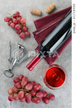 Bottle of wine, wine glass, grapes and corkscrew on gray background. Bottle of wine, wine glass, grapes and corkscrew on gray background. 61718400