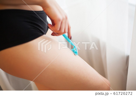 Caucasian woman shaving legs with razor at home 61720272