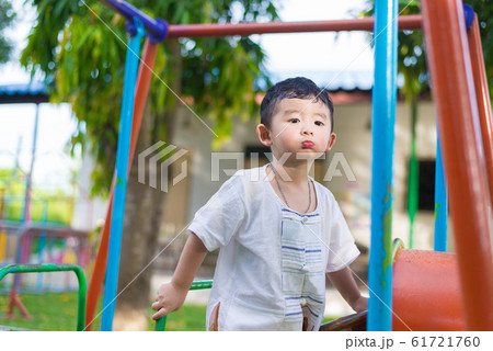Young Asian boy play a iron train swinging at the Young Asian boy play a iron train swinging at the 61721760