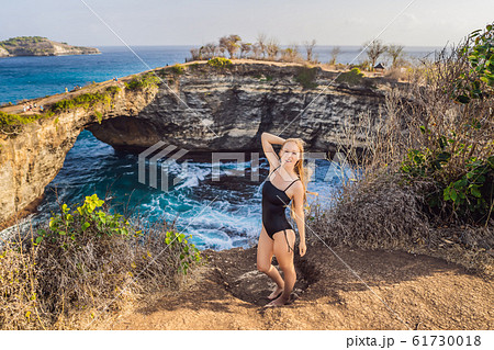 Young woman tourist near Broken Beach in Nusa Penida, Indonesia Angel's BillaBong Beach. Popular 61730018