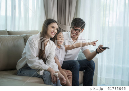 Asian family see the movie togather on sofa in 61735046