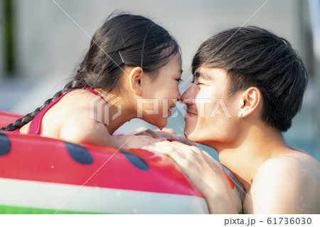 Asian father play with her daughter in a swimming Asian father play with her daughter in a swimming 61736030