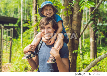Happy father and little boy walking in summer park. adoption and people concept 61736288
