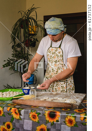 Young man prepares homemade dumplings for dinner. 61737152