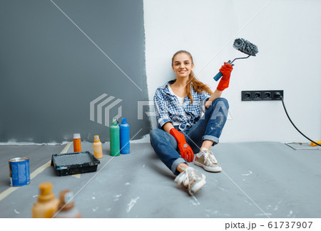 House painter sitting on the floor after work 61737907
