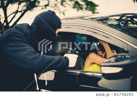 Criminal or Bandit wear black mask use gun point to woman in black car at the parking trying to rob money and hurting her Criminal or Bandit wear black mask use gun point to woman in black car at the parking trying to rob money and hurting her 61738265