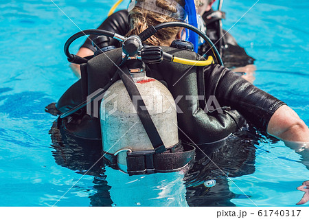 grey scuba diving air oxygen tank on the back of a scuba diver 61740317