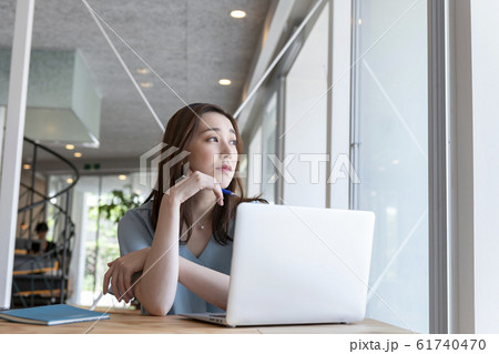 頬杖をついて考え込む女性 61740470