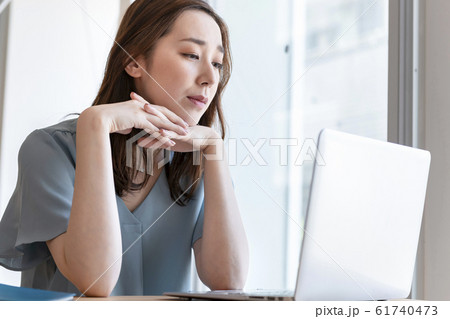 パソコンの画面を見ながら考え込む女性 パソコンの画面を見ながら考え込む女性 61740473