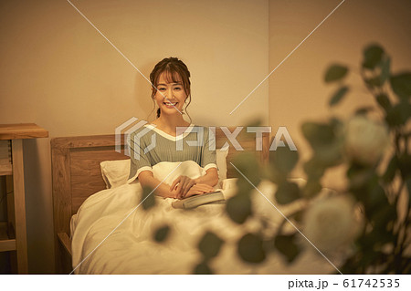 部屋でくつろぐ女性 本 部屋でくつろぐ女性 本 61742535