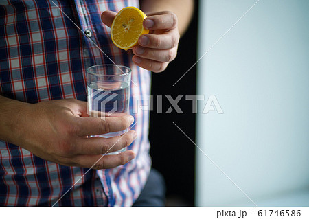 overweight man squeezing lemon juice into water 61746586