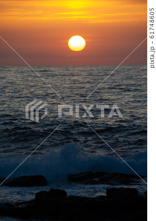 水平線に沈む夕陽と波 水平線に沈む夕陽と波 61748605