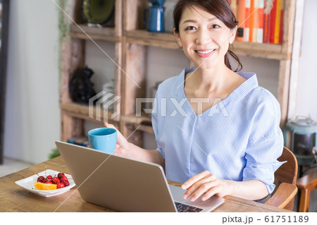 部屋でラップトップコンピューターを見る女性 部屋でラップトップコンピューターを見る女性 61751189