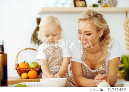 Happy mother and little daughter cooking in kitchen. Spending time all together, family fun concept 61755449