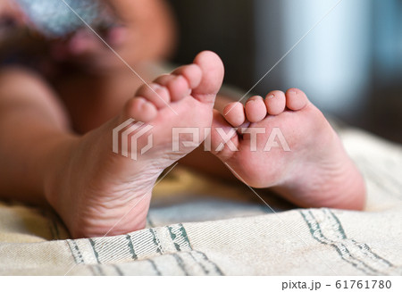 Feet of a little girl on the bed, close-up Feet of a little girl on the bed, close-up 61761780