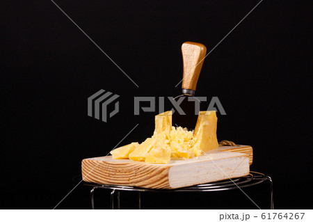 Piece of fresh tasty cheese on a black background Piece of fresh tasty cheese on a black background 61764267
