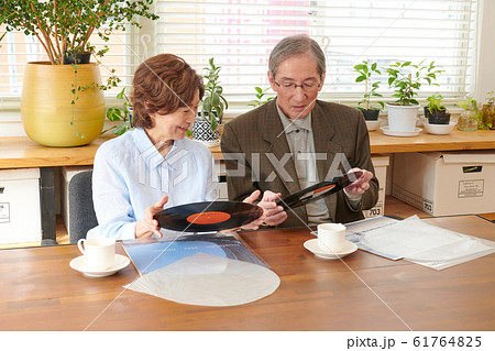 レコードを懐かしんで見るシニア夫婦 61764825