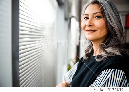 Portrait of happy lady in office near the window stock photo 61768504