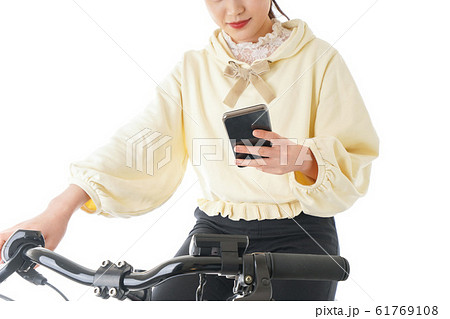自転車でスマホを使う若い女性 61769108