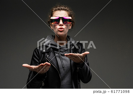 portrait of attractive caucasian girl in stylish glasses, gray sweatshirt and black leather jacket 61771098
