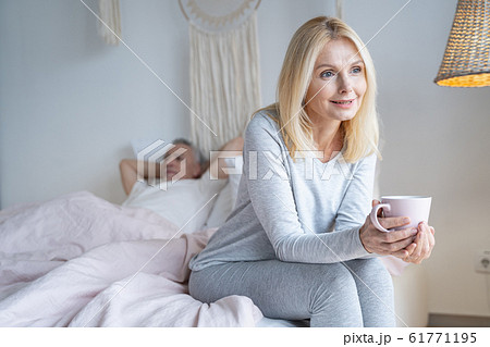 Relaxed woman enjoying tea in bedroom stock photo 61771195