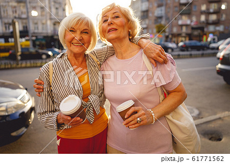 Friends being glad meeting each other in the street 61771562