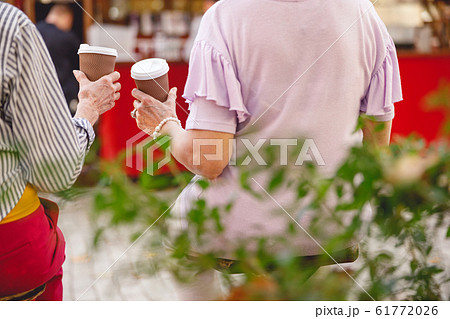 Friends having their morning coffee in park Friends having their morning coffee in park 61772026