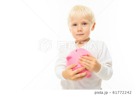 charming cute blond boy holding a piggy bank on a white background with copy space charming cute blond boy holding a piggy bank on a white background with copy space 61772242