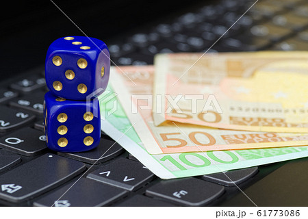 Dices and euro banknotes on computer keyboard Dices and euro banknotes on computer keyboard 61773086