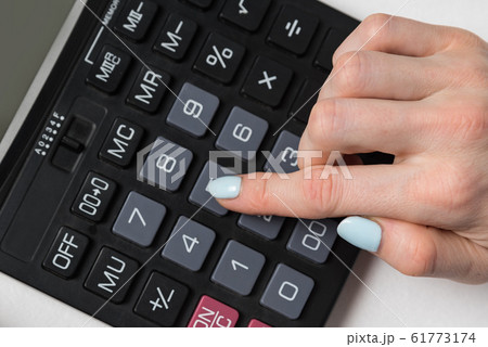Calculator and female hand close up on white 61773174