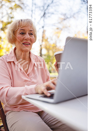 Interested old woman replying to an incoming e-mail 61773394
