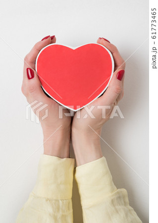 Vintage style red heart shaped box in female hand Vintage style red heart shaped box in female hand 61773465