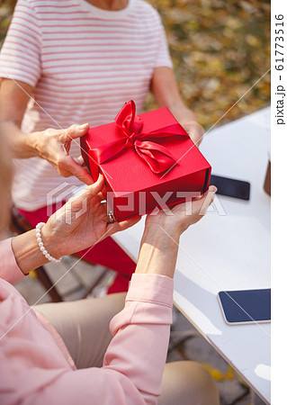 Aged woman getting her first birthday gift 61773516
