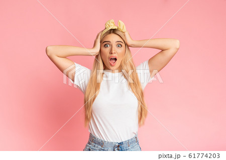 Amazed teenager looking at camera grabbing head Amazed teenager looking at camera grabbing head 61774203