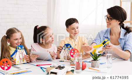 Teacher showing diy robot to students, explaining new project 61774395