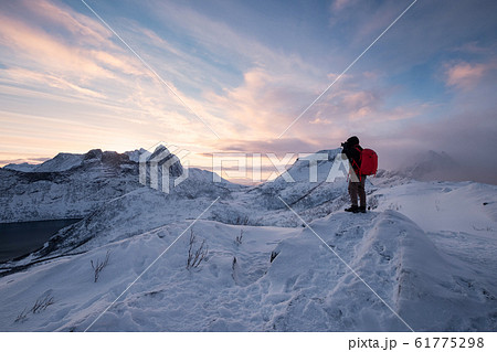 Photographer taking a photo on top of snowy 61775298