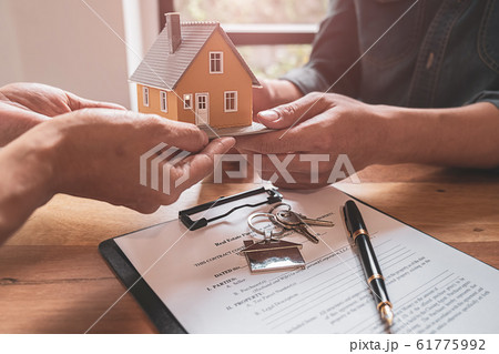 House model with agent and customer discussing for contract to buy, get insurance or loan estate. 61775992