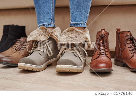 Woman chooses comfortable shoes among a bunch of 61776146
