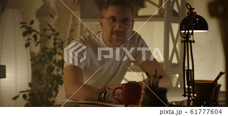 Artist sitting at desk and writing 61777604